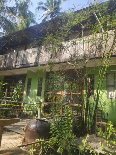 a green house with a fence in front of it at Oliver`s Laguna ECO Lodge Hotel in Ngapali