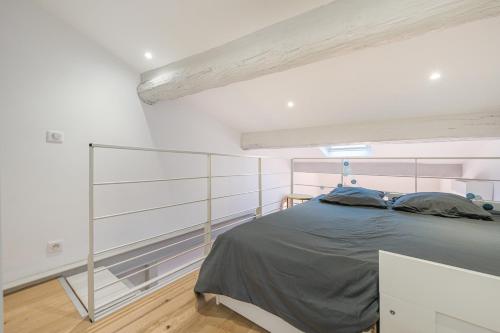 a bedroom with a bed in a white room at Le Duplex in Villefranche-sur-Mer