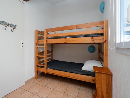 Ce lit superposé en bois se trouve dans un dortoir doté d'une fenêtre. dans l'établissement Samaria Village N11 - 2P6, au Cap d'Agde