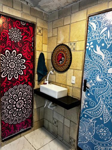 a bathroom with a sink and a red and blue wall at Pousada Alameda Boa Vista in Recife