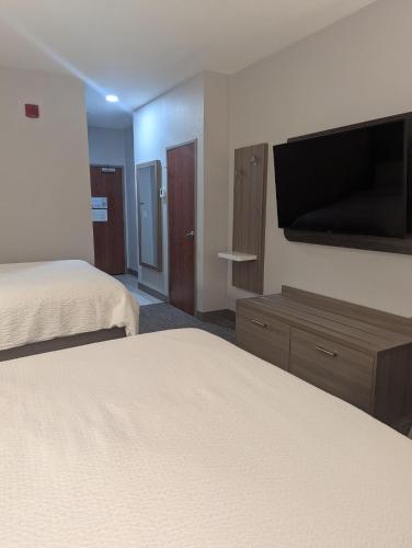 a hotel room with two beds and a flat screen tv at Holiday Inn Express Hotel & Suites Loveland by IHG in Loveland
