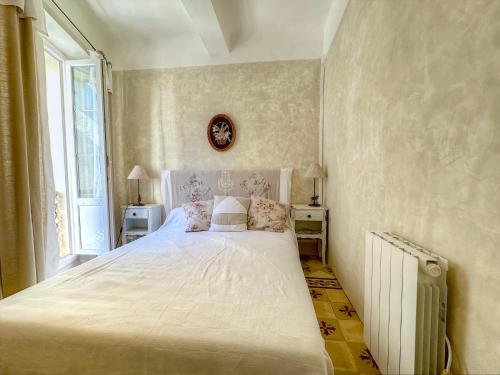 a bedroom with a white bed and a window at Appartement provençal, Aups in Aups