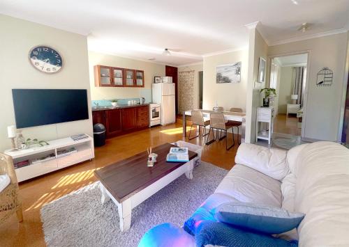 a living room with a couch and a table at Acacia Retreat in Dunsborough