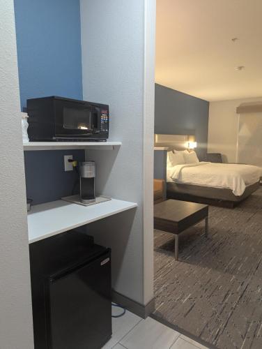 a hotel room with a bed and a flat screen tv at Holiday Inn Express Hotel & Suites Loveland by IHG in Loveland