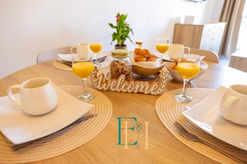 une table avec des verres de jus d'orange et de la nourriture dessus dans l'établissement Le BOHEME - Séjour en Petite Camargue - 4 personnes, au Grau-du-Roi