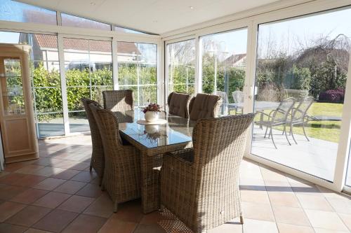 a conservatory with a glass table and chairs at Kustverhuur, Breskens Zwin 242 in Breskens