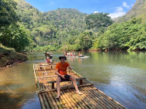 a man sitting on a raft on a river at Khao Phang Camping in Ban Pha Saeng Lang