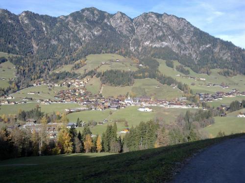 a town on a hill with mountains in the background at Haus Theresia in Alpbach