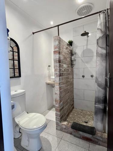 a bathroom with a white toilet and a shower at Dolphin Circle Bed and Breakfast in Plettenberg Bay