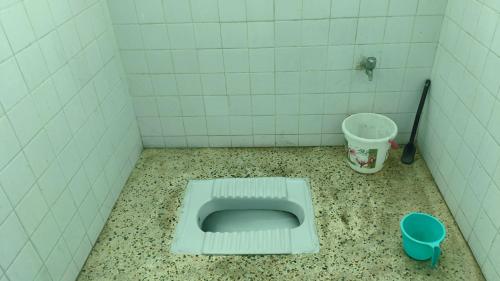 a bathroom with a toilet in the floor of a stall at Vimla Homestay in Faizābād