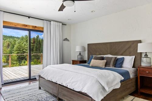 a bedroom with a large bed and a balcony at Spacious Mountain Retreat set on 7 acres & Pond in Stowe