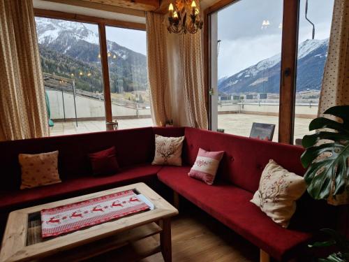 a red couch in a room with a large window at Panorama-Ferienhaus im Stubaital in Mieders