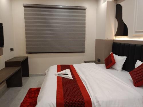 a bedroom with a bed with a red and white blanket at Hotel The C G Villa Just a Minute Away From New Delhi Railway Station and Connaught place in New Delhi