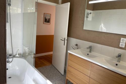 ein Badezimmer mit Badewanne, Waschbecken und Spiegel in der Unterkunft Villa en pleine nature avec piscine privée - 8 couchages - 4 chambres - Proche St Antonin Noble Val in Penne