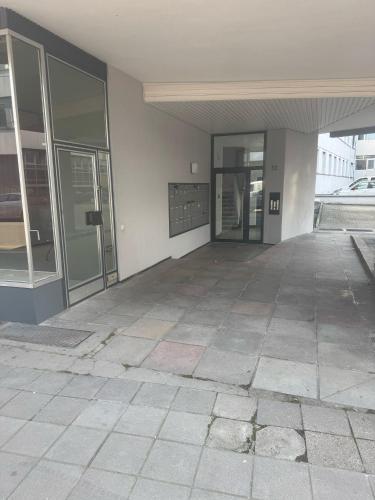 an empty building with glass doors and a sidewalk at Stuttgart mitte in Stuttgart