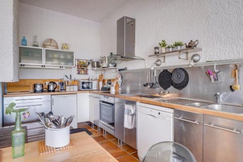 une cuisine avec des appareils en acier inoxydable et un comptoir dans l'établissement La maison des Pins au Pyla sur mer, à La Teste-de-Buch