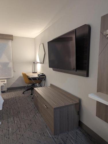 a hotel room with a large flat screen tv on the wall at Holiday Inn Express Hotel & Suites Loveland by IHG in Loveland