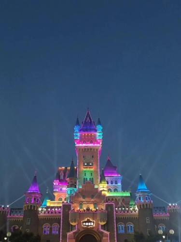 a disney castle lit up in purple and green at Nostalgia Hotel Tianjin Binhai Tanggu 时光漫步酒店天津滨海塘沽站店 Free fresh ground coffee,Free laundry service in Tianjin