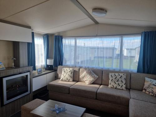 a living room with a couch and a large window at HAPs Holiday Home - Haven The Orchards in Brightlingsea