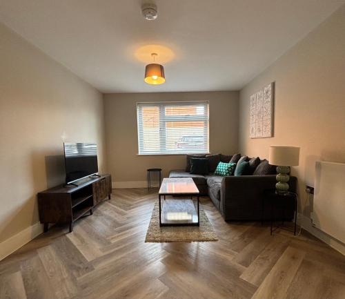 a living room with a couch and a television at Modern Apartment - BHX NEC - Free Secure Gated Parking in Solihull