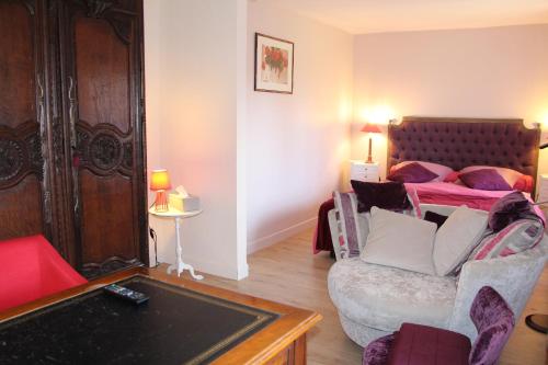 a bedroom with a bed and a couch and a chair at L'écurie de Vieux-Moulin in Vieux-Moulin