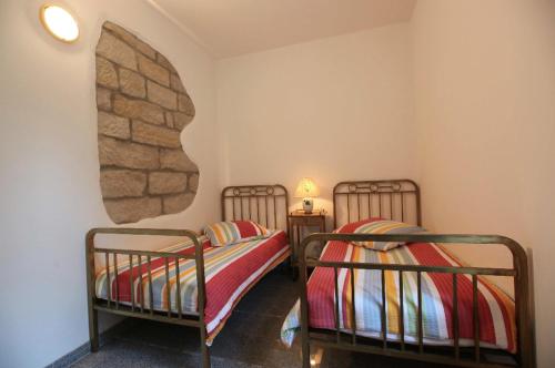 two twin beds in a room with a stone wall at Apartmenthaus Saxonia in Bad Schandau