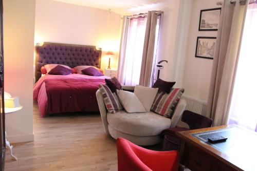 a bedroom with a bed and a chair and a table at L'écurie de Vieux-Moulin in Vieux-Moulin