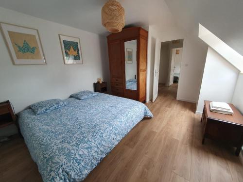 une chambre avec un lit et un parquet dans l'établissement Charming Breton farmhouse, à Rédené