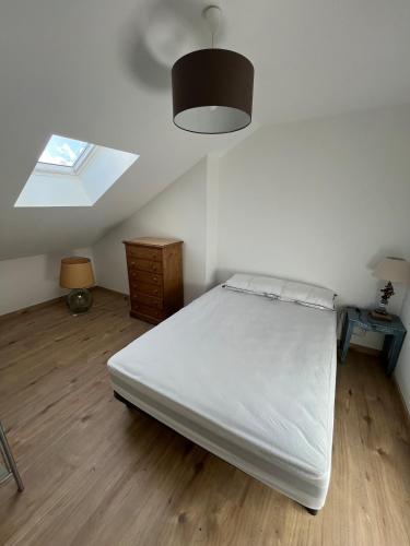 une chambre avec un lit blanc et une fenêtre dans l'établissement 2 pièces neuf, au coeur de ville 37m2, au Creusot