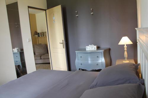 a bedroom with a bed and a dresser and a mirror at L'écurie de Vieux-Moulin in Vieux-Moulin