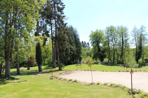 a park with a playground in the grass at L'écurie de Vieux-Moulin in Vieux-Moulin