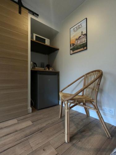 une chaise en bois dans une pièce avec une cuisine dans l'établissement Chambre indépendante rénovée, à 2 pas de la plage, à Savonnières