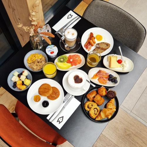 a table filled with breakfast foods on a table at Afterwork Hotel in Etoy