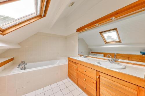 une salle de bain avec deux lavabos et une baignoire dans l'établissement Maison pour 8 avec jardin, 300 m de la mer, à Saint-Gildas-de-Rhuys