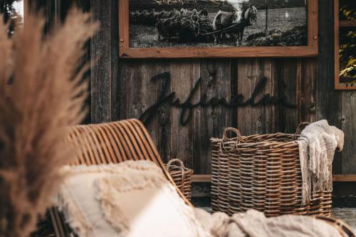a wicker chair and a basket on a wall with a picture at Jufenalm BOHO & Wellnesshotel in Maria Alm am Steinernen Meer