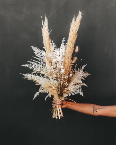 a person holding a bouquet of wheat at Jufenalm BOHO & Wellnesshotel in Maria Alm am Steinernen Meer