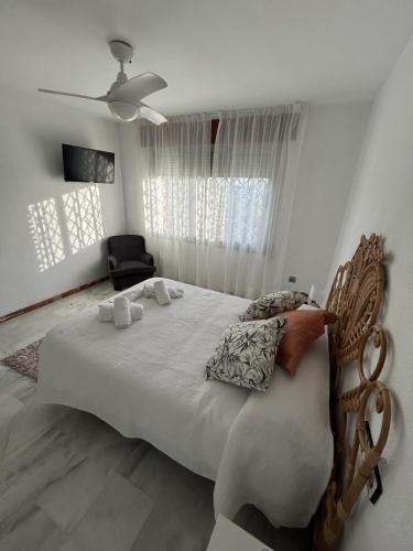 a bedroom with a large bed and a chair at Carmen Home in Córdoba