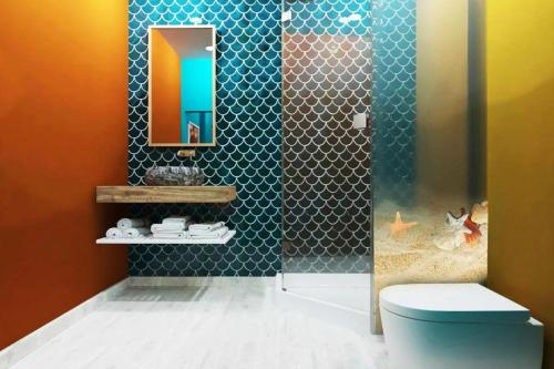 富国Skyline Hotel Phú Quốc的带淋浴、卫生间和镜子的浴室