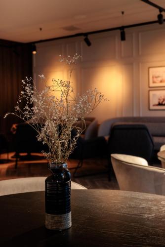 a bottle with flowers in it sitting on a table at Pillows City Hotel Brussels Centre in Brussels