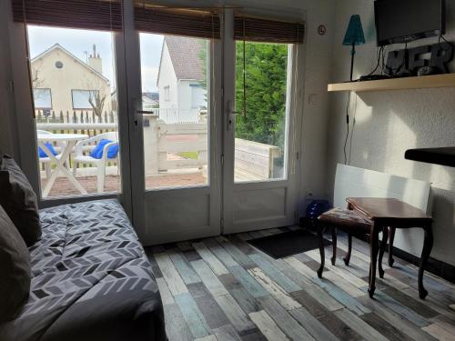 - une chambre avec un lit, un bureau et une porte coulissante en verre dans l'établissement Logement calme proche du Touquet, à Cucq