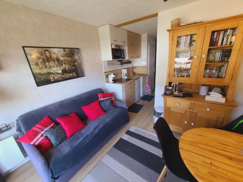 - un salon avec un canapé bleu et des oreillers rouges dans l'établissement Studio 3 étoiles Les Helianthes, à La Clusaz