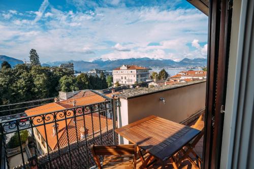 a balcony with a wooden table and a view of a city at Suite Romantic vista Lago in Stresa