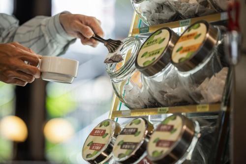 a person is holding a cup and a spoon at Kindness Hotel - Zhongshan Bade Branch in Kaohsiung