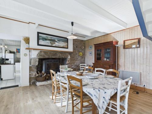 une salle à manger avec une table et des chaises et une cheminée dans l'établissement À 400m de la plage, charmante maison pour 7, à Plouguerneau
