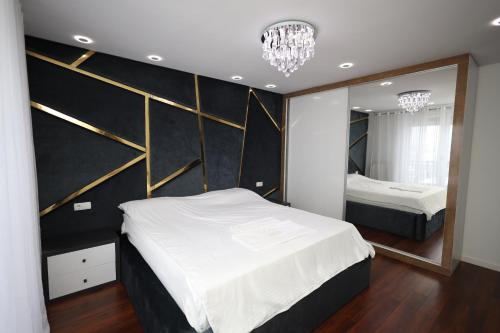 a bedroom with two beds and a large mirror at Dodona ApartHotel in Prishtina in Pristina