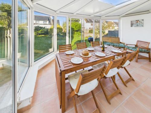 une salle à manger avec une table et des chaises en bois dans l'établissement Maison avec veranda pour 6 personnes, au Guilvinec