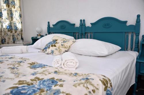 a blue bed with two rolled towels on it at Hotel Miorita Neptun in Neptun