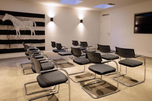 a room with chairs and a wall with a picture of a horse at Pillows City Hotel Brussels Centre in Brussels