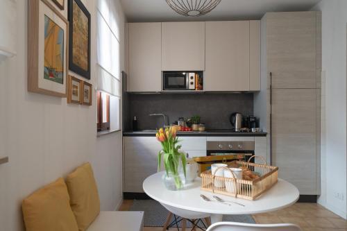 a kitchen with a table with a vase of flowers on it at Via Cesarini Apartment in San Vito al Tagliamento