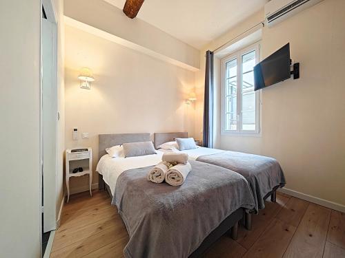 a bedroom with two beds with towels on it at Croisette carre d'or in Cannes